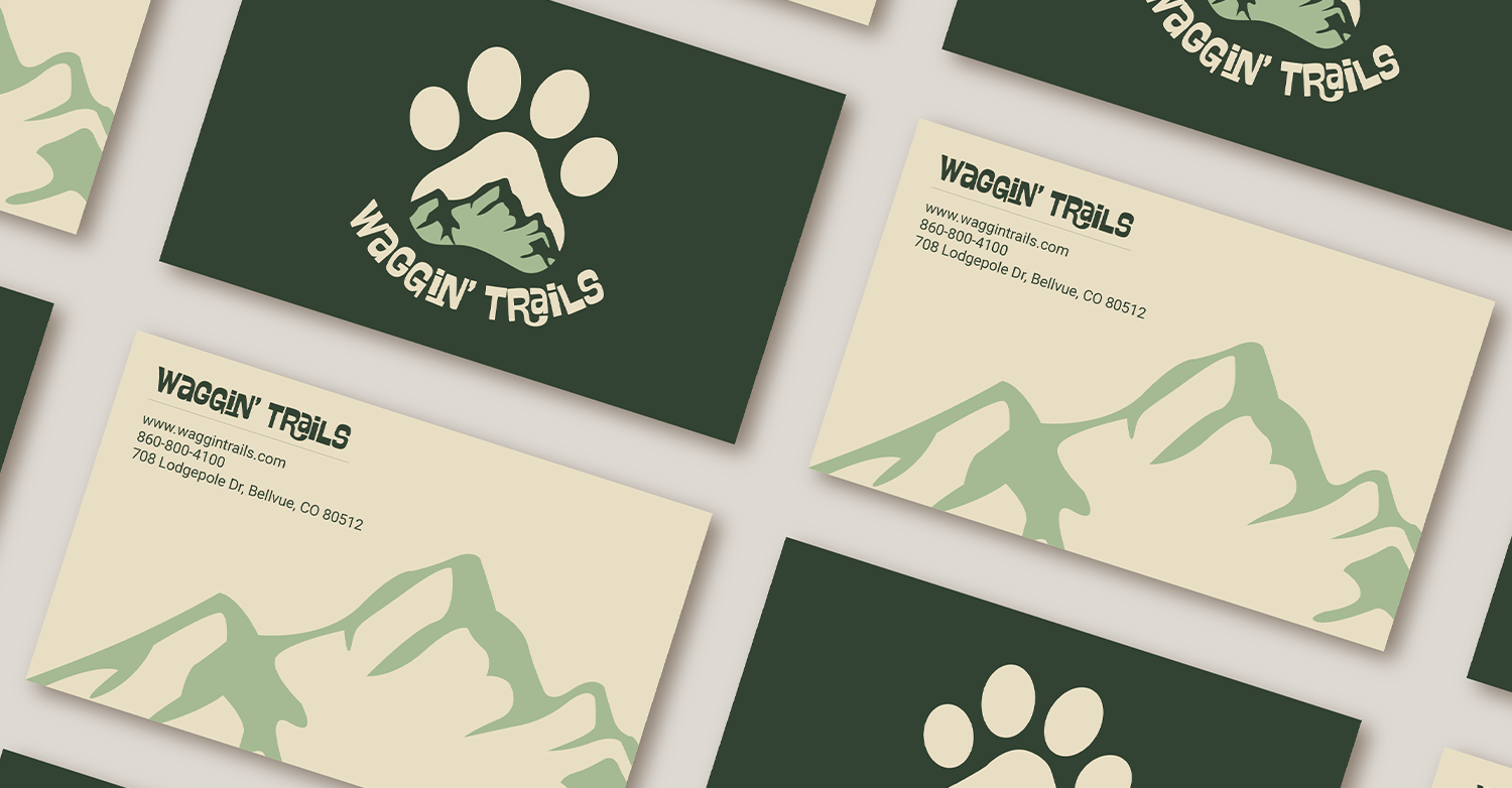 Wide view of the Waggin' Trails buisness card showcasing mountain graphic and logo.